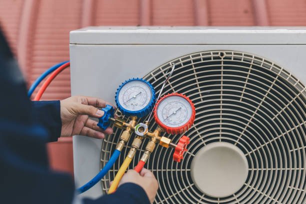 HVAC technician checking an outdoor AC unit